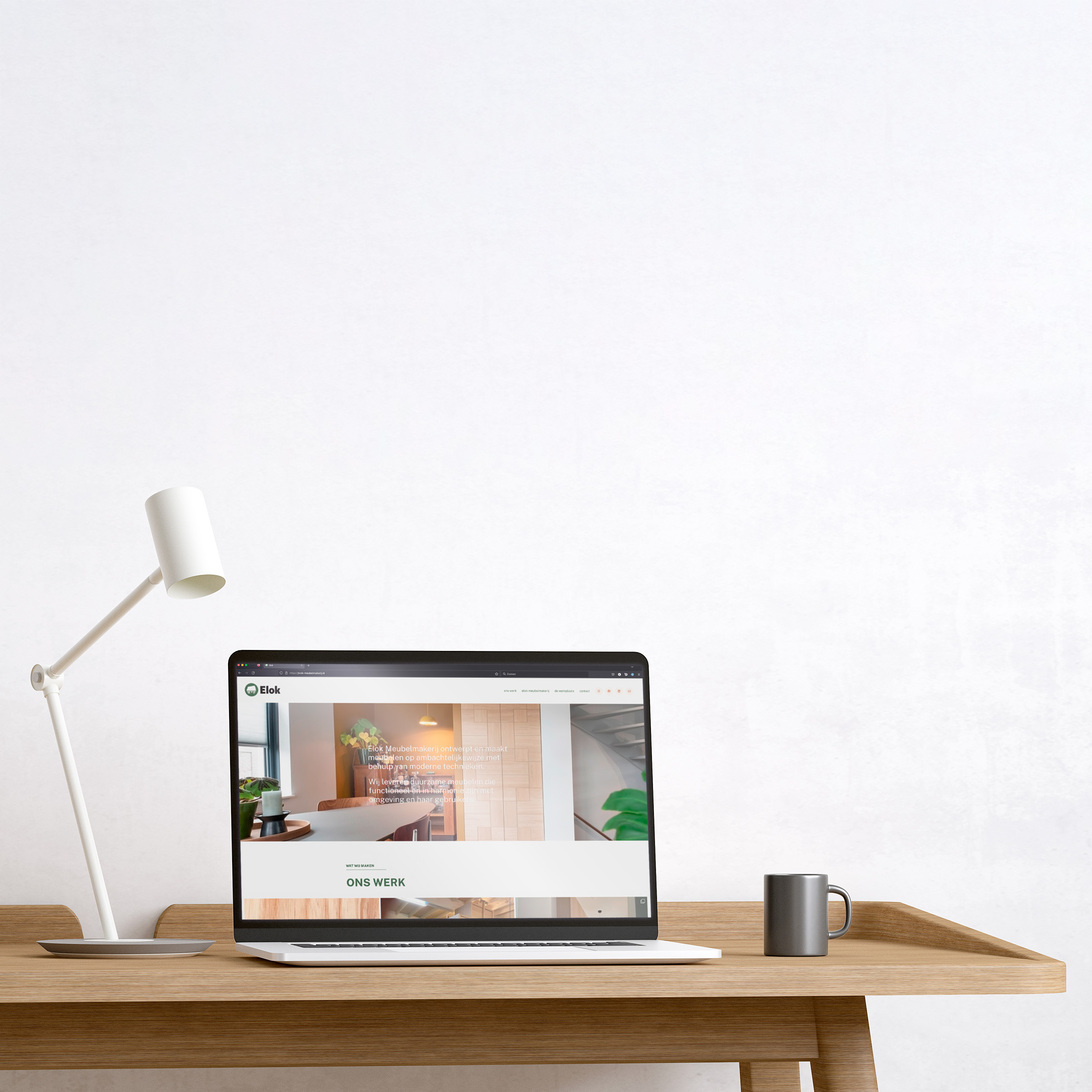 De Elok website, zichtbaar op een apple laptop die bovenop een design tafel staat.